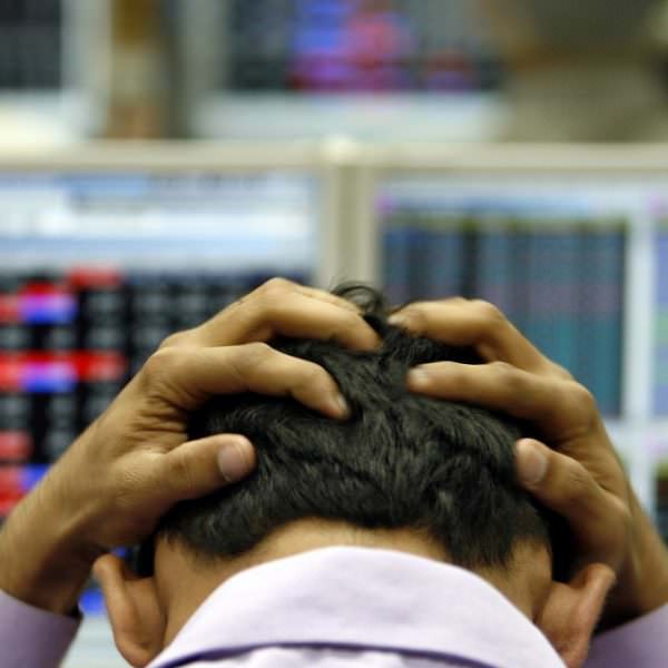 Person holding his head, stressed, stocked market