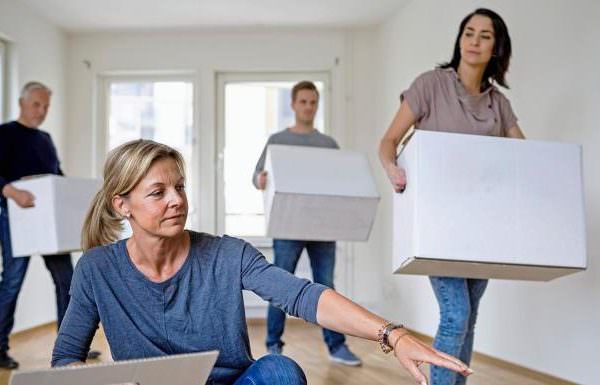 People moving boxes into an empty room