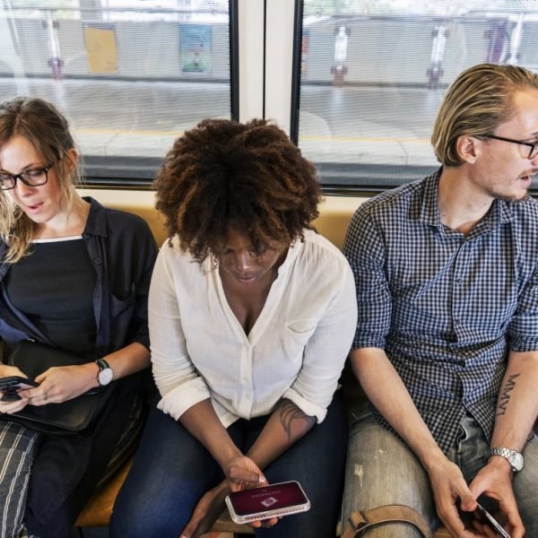 Multicultural millennials texting on the phone together